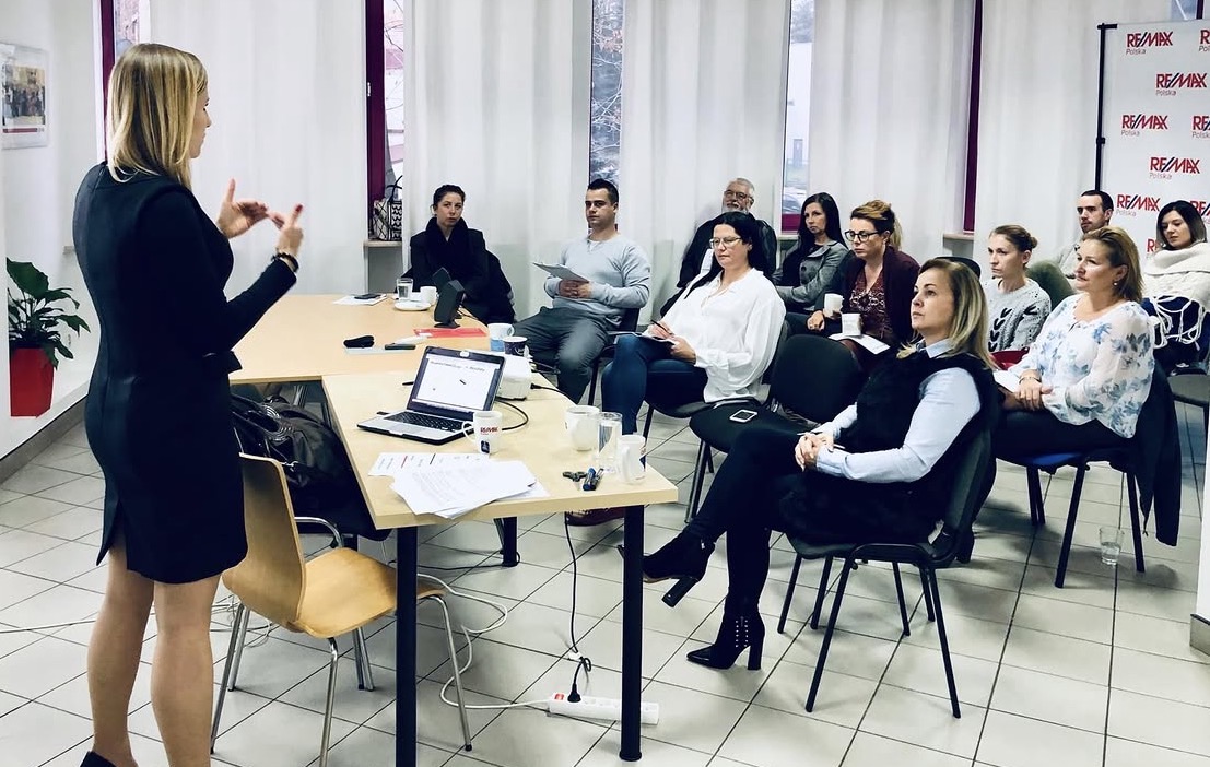 Sylvana Kozak leading a workshop in a black dress