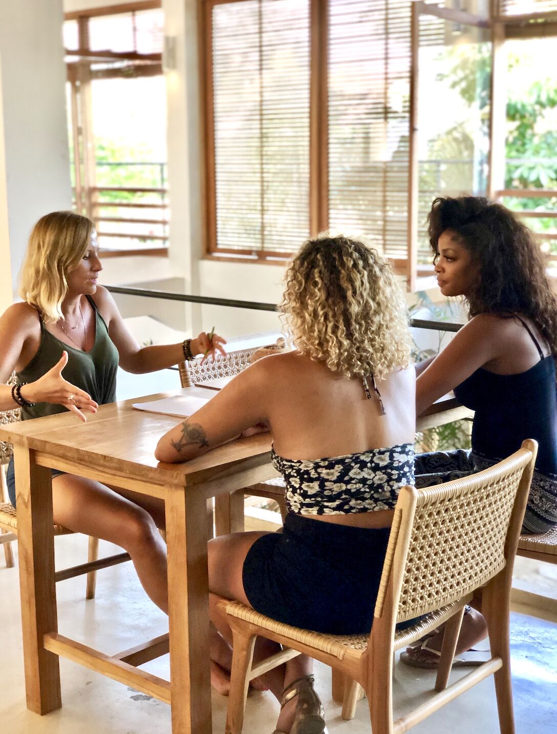 Sylvana Kozak in conversation with two women around a table